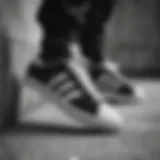 Adidas black and white skateboarding shoes on a concrete surface