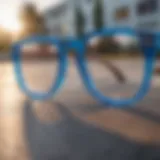 A close-up view of clear blue lens glasses resting on a skateboard deck.