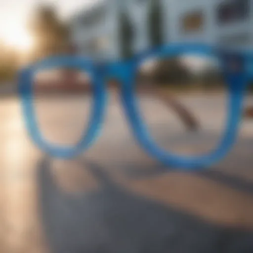 A close-up view of clear blue lens glasses resting on a skateboard deck.