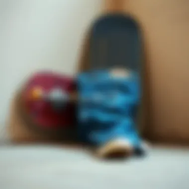 A skateboard resting against a wall, with blue jeans featuring cargo pockets laid beside it.