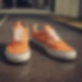 Close-up of orange checkerboard Vans on a skateboard.