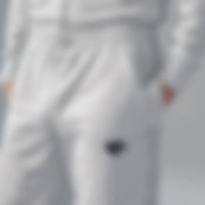 Close-up of distinct white Adidas tracksuit pants highlighting their fabric and design details