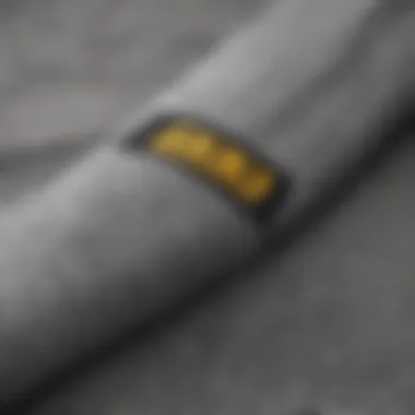 Close-up of the fabric texture and stitching of grey Adidas sweats, highlighting quality and design.