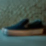 Classic black slip-on Vans against a textured surface